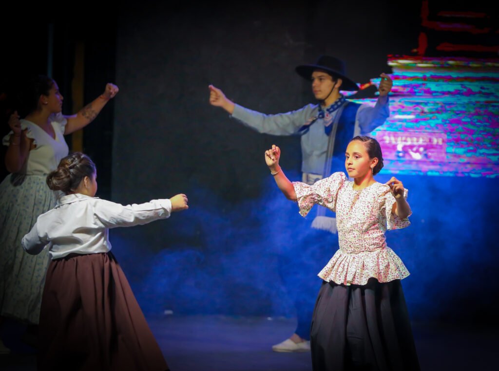 Traditional dance performance under blue theatrical light