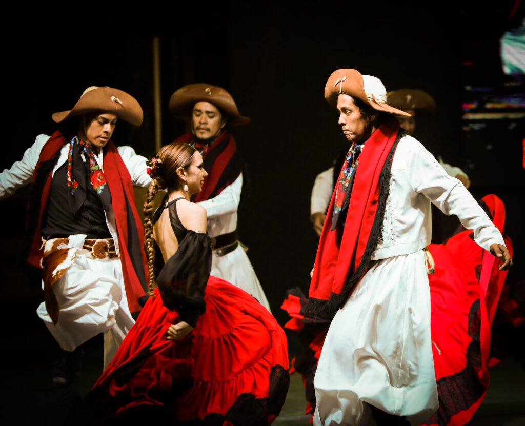 Folk dancers in red and white traditional costumes during stage performance