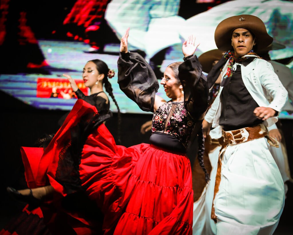 Traditional dancers captured in dynamic red fabric movement
