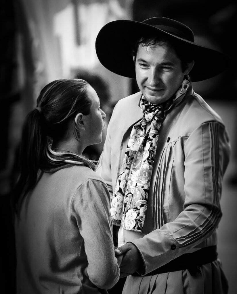 Young girl and folkloric performer holding hands during cultural gathering